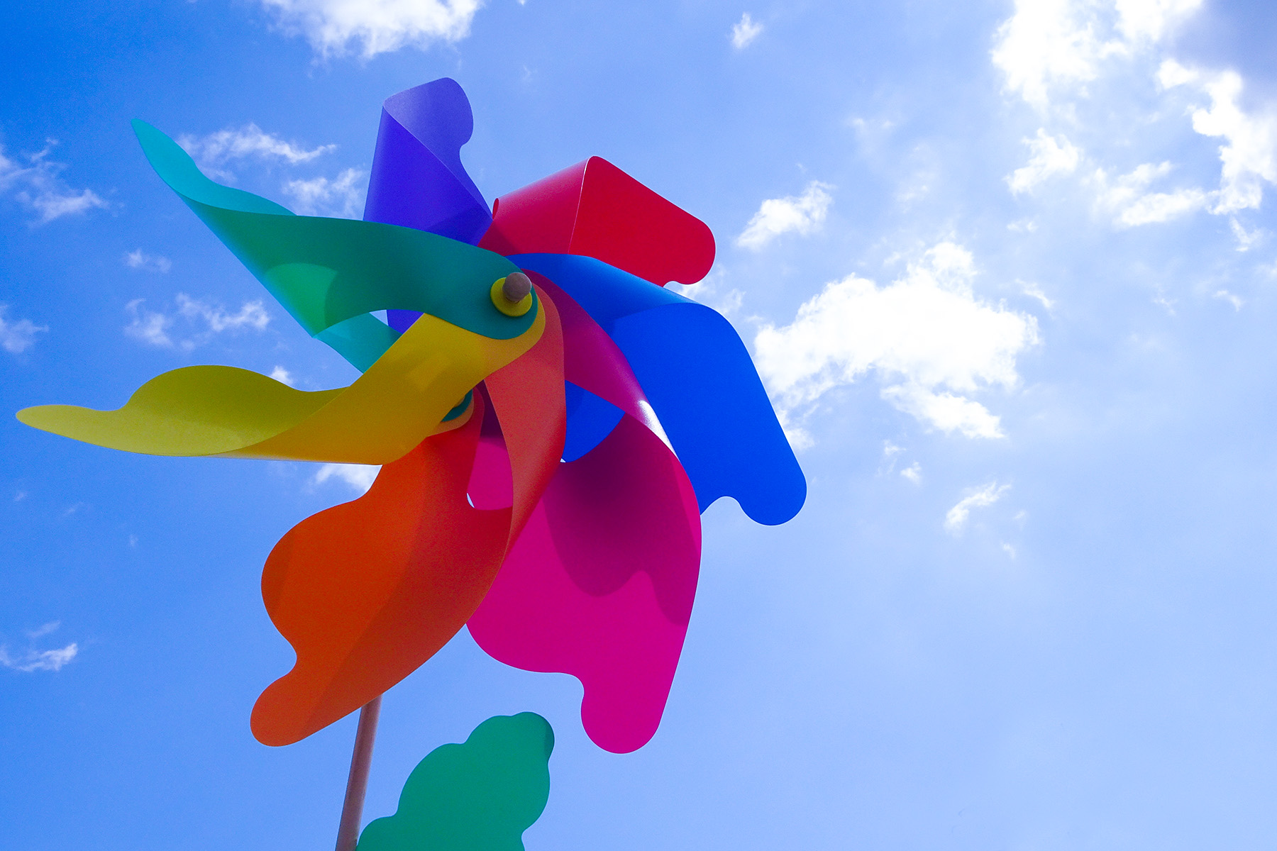 An image of a brightly colored pinwheel under blue skies. The pinwheel, a small lawn ornament that catches the wind and spins, is meant to convey the idea of extremely local weather, like the weather in your backyard.